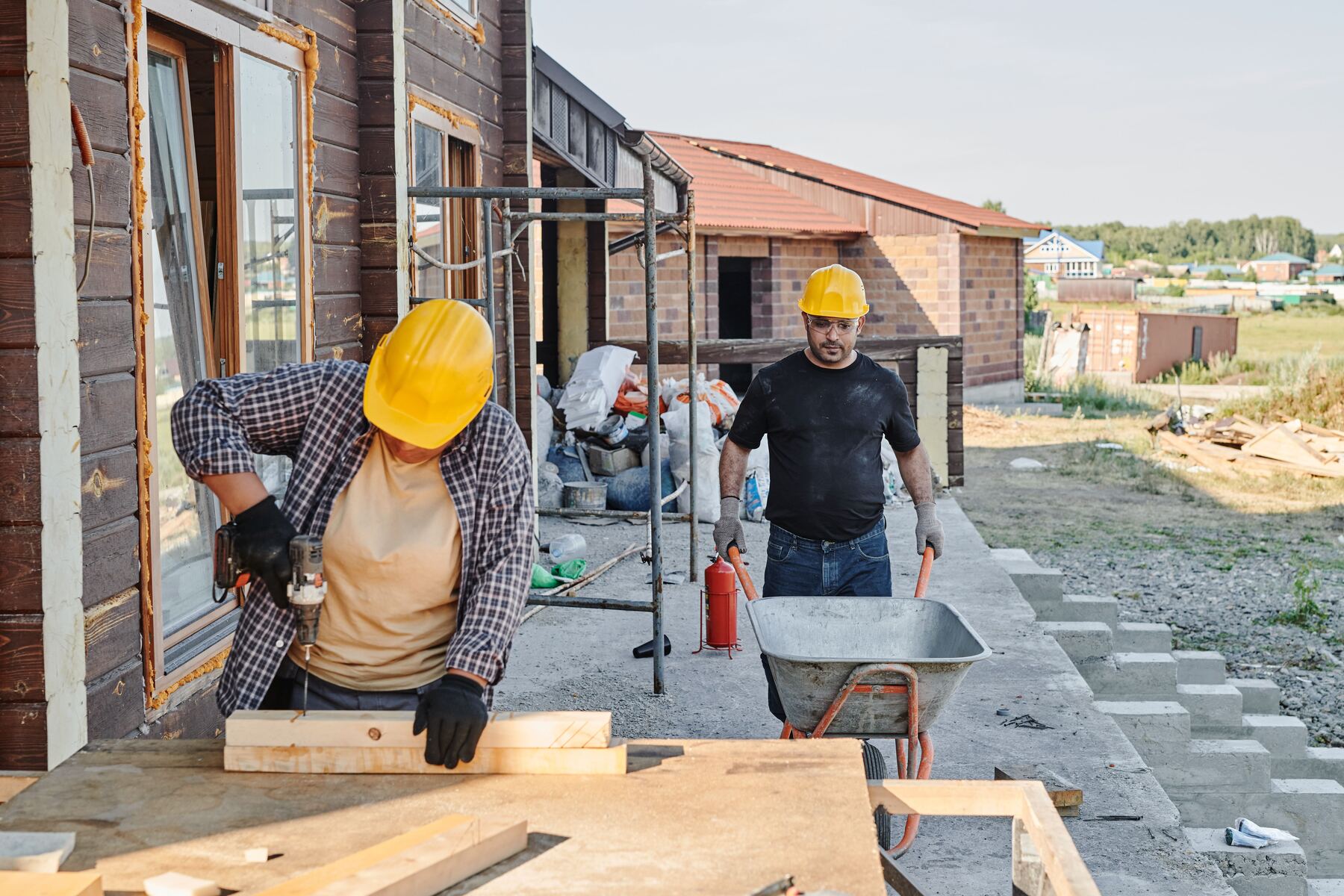 Two builders working outside a home under construction