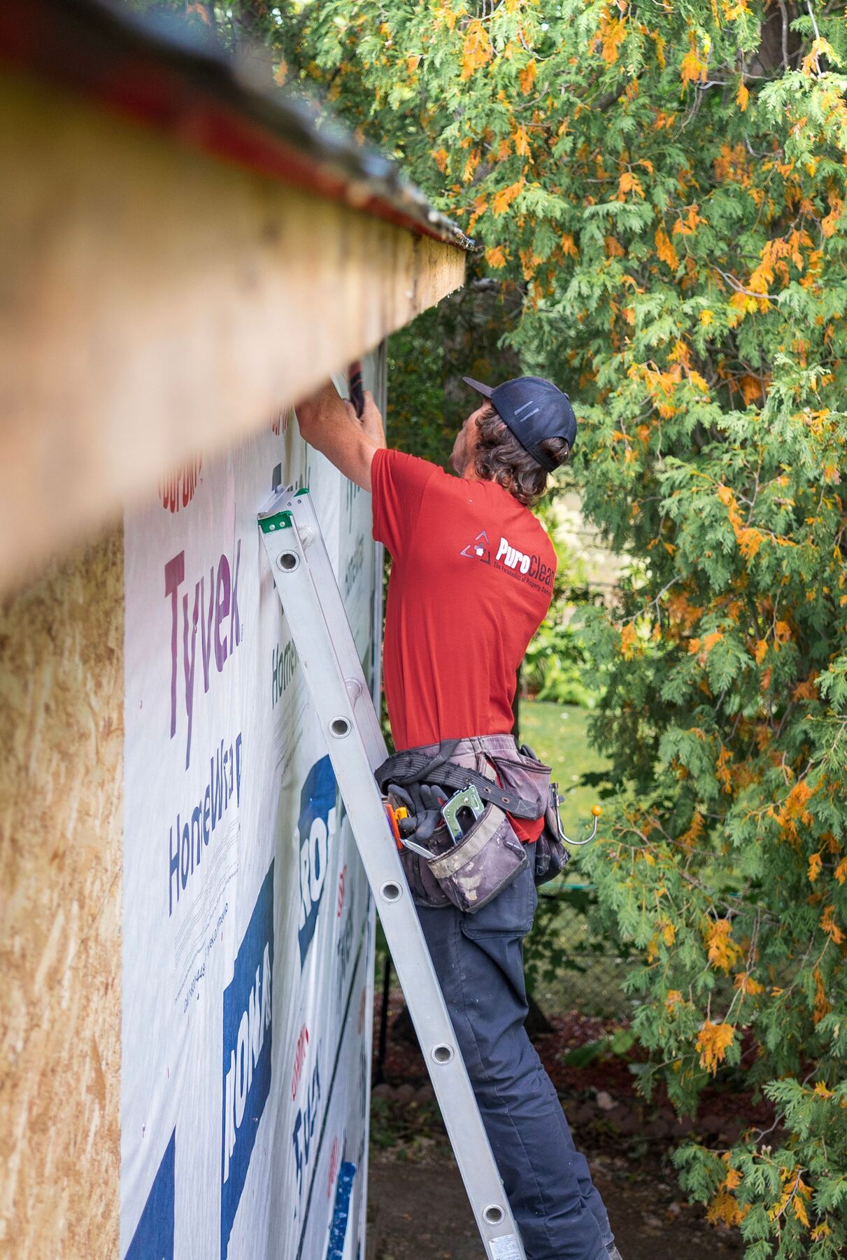 Worker installing house wrap on a home addition